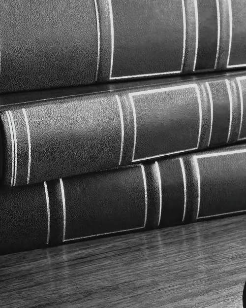 Volúmenes encuadernados sobre un escritorio de madera.