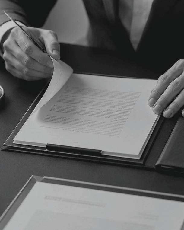 Manos revisando un documento sobre un escritorio.